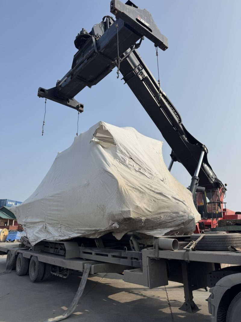 Выгрузка катера краном-манипулятором с низкорамного полуприцепа на площадке в Якутске
