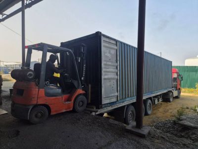 Вилочный погрузчик выгружает паллеты из сорокафутового контейнера, не снимая его с полуприцепа
